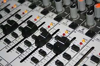Close-up of Audio Mixing Console Faders and Knobs