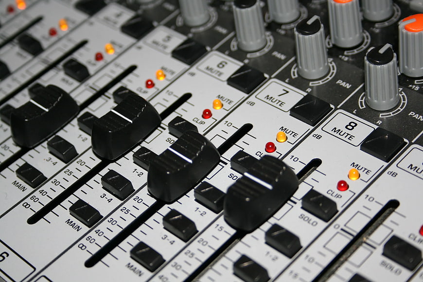 Close-up of Audio Mixing Console Faders and Knobs