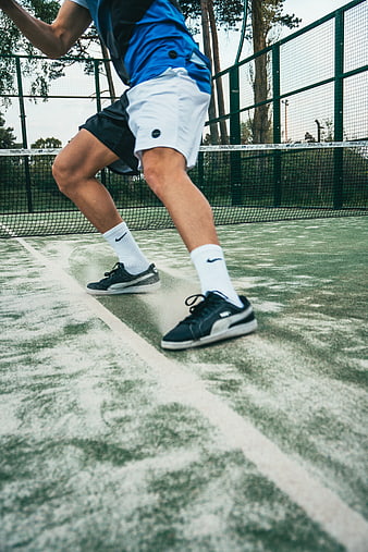 Low angle action shot of tennis player sneakers on court