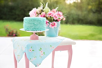 Pastel blue ruffled cake with pink flowers on a table