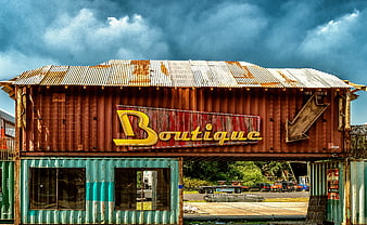 Rusty shipping container boutique with dramatic sky