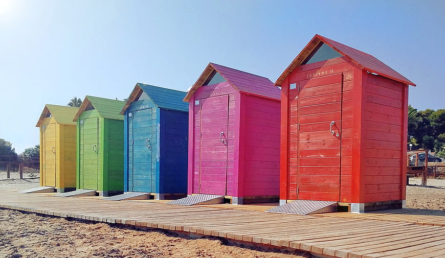 Colorful wooden beach huts on a sunny boardwalk