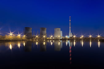 Night view of power plant with cooling towers and reflections