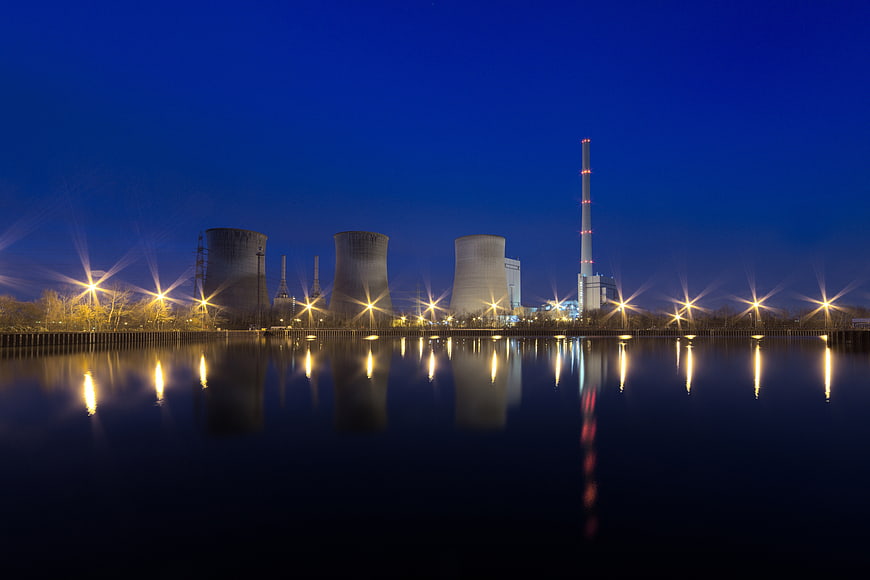 Night view of power plant with cooling towers and reflections