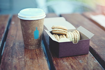 Coffee cup and macarons on rustic wooden table