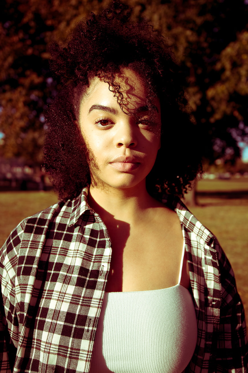 Portrait of Young Woman with Curly Hair in Plaid Shirt