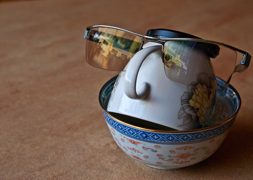 Glasses Resting On Upside Down Porcelain Cup In Decorative Bowl