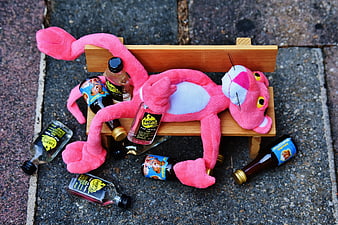Pink Panther plush toy drunk on miniature alcohol bottles