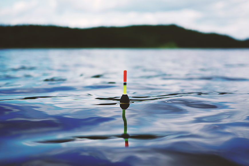 Colorful Fishing Bobber Floating on Calm Blue Water