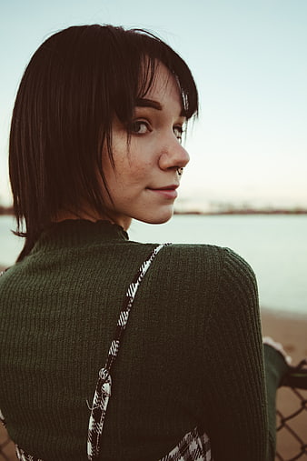 Young Woman with Piercing Looking Back at Beach