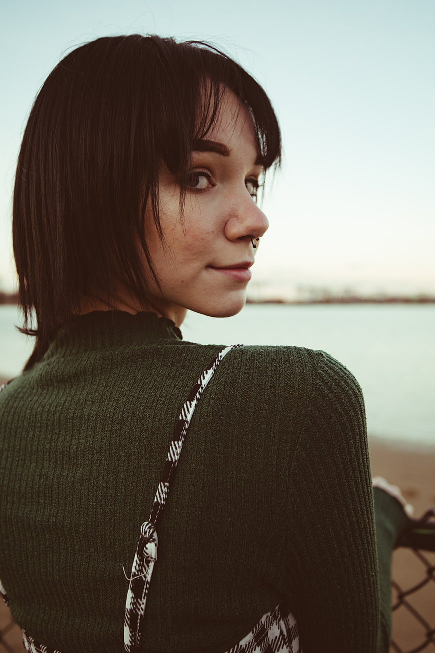 Young Woman with Piercing Looking Back at Beach
