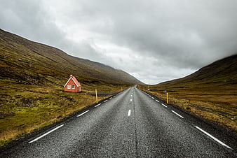 Lonely red house on a long road in Icelandic highlands
