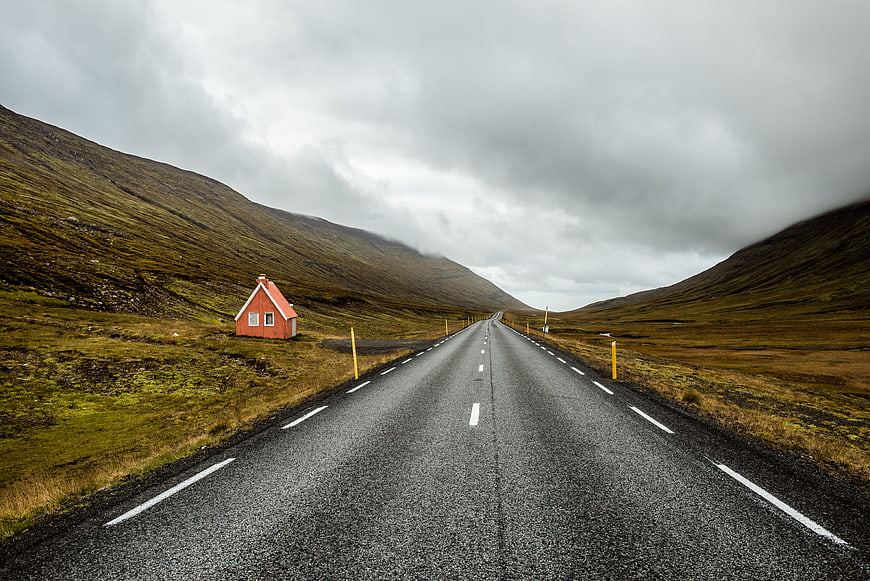 Lonely red house on a long road in Icelandic highlands