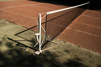 Empty Tennis Court Net on Clay Surface