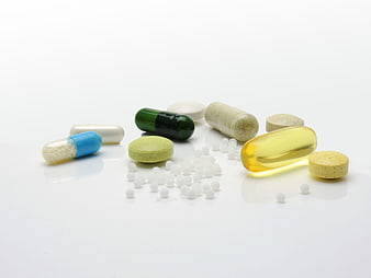 Assorted Medication Pills and Capsules on White Background