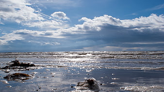Scenic coastal landscape with dramatic clouds and sparkling ocean waves