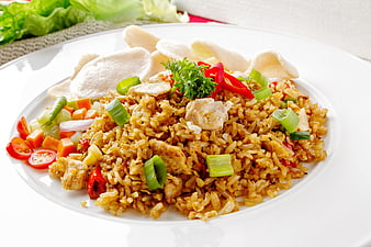Asian Chicken Fried Rice With Vegetables And Crispy Crackers On White Plate