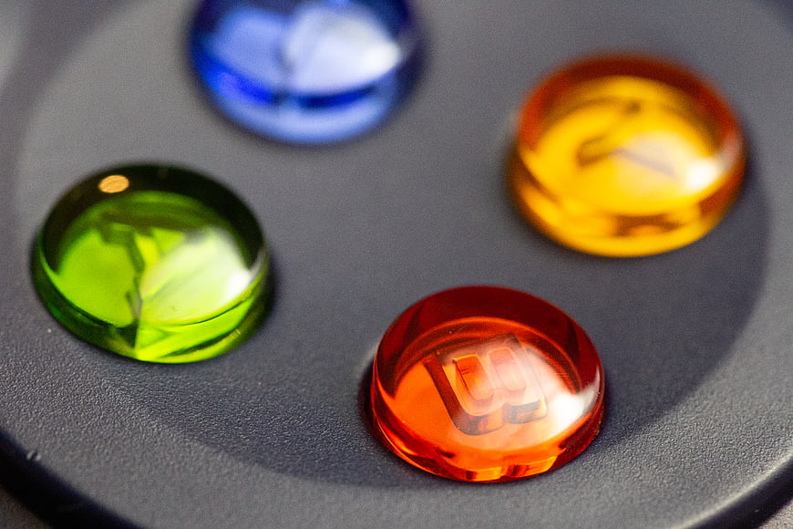 Close-up of colorful game controller buttons on dark surface