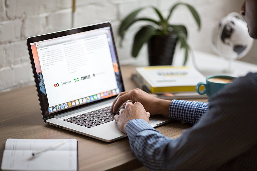 Man Typing on Laptop in Modern Workspace