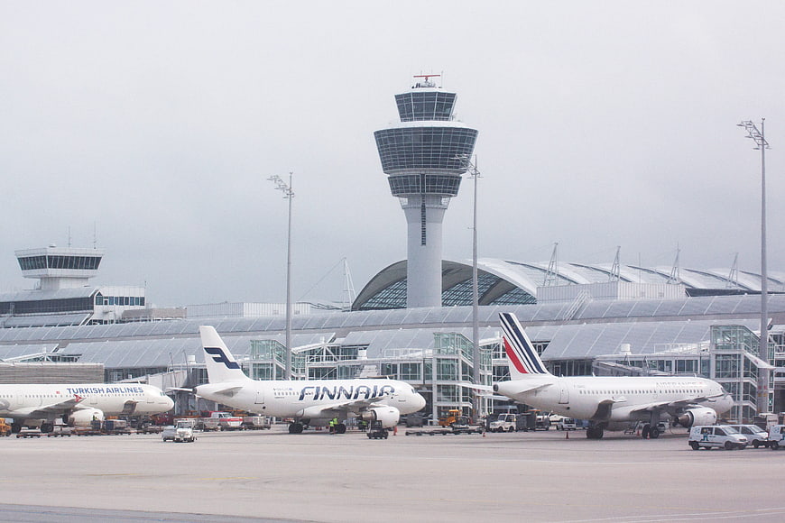 Airplanes parked at Munich Airport tarmac with control tower