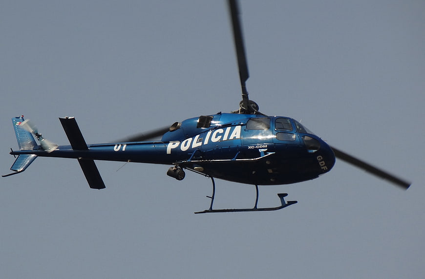 Blue Police Helicopter In Flight Against Clear Sky