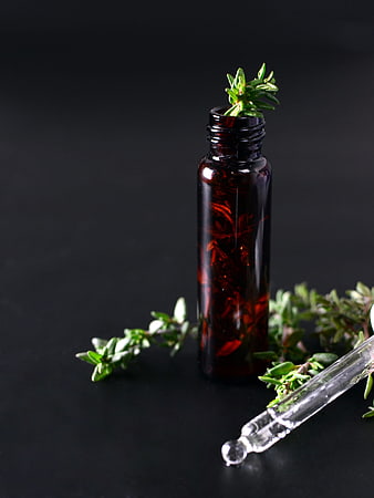Amber Essential Oil Bottle with Fresh Thyme Sprigs and Glass Dropper