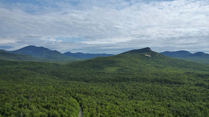 Aerial View of Lush Green Mountain Forest with Winding Road