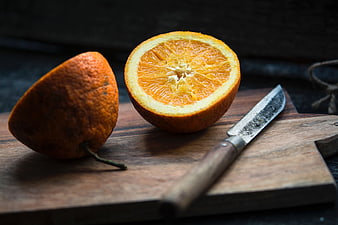 Fresh Cut Orange on Wooden Board with Knife