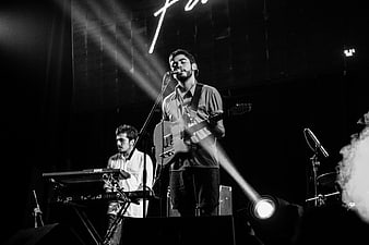 Black and white concert photo of male singer with electric guitar