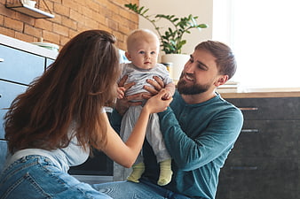 Happy Parents Holding Baby in Modern Kitchen Interior