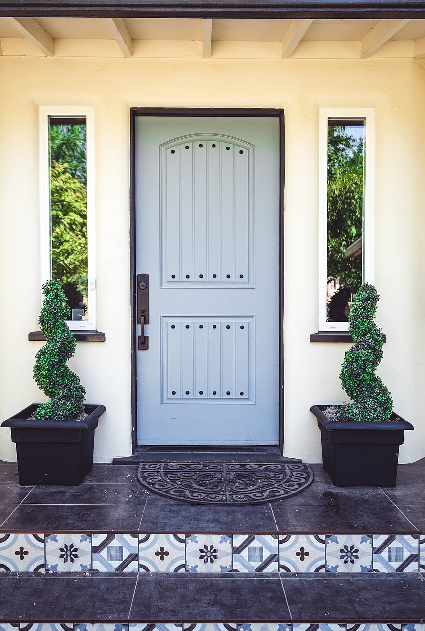 Symmetrical Blue Front Door with Spiral Topiaries