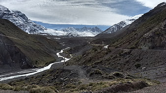 Snowy mountain range and river valley in Chilean Andes