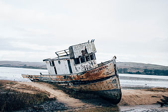 Abandoned Rusty Boat Named Point Reyes Stranded on Sandy Shore