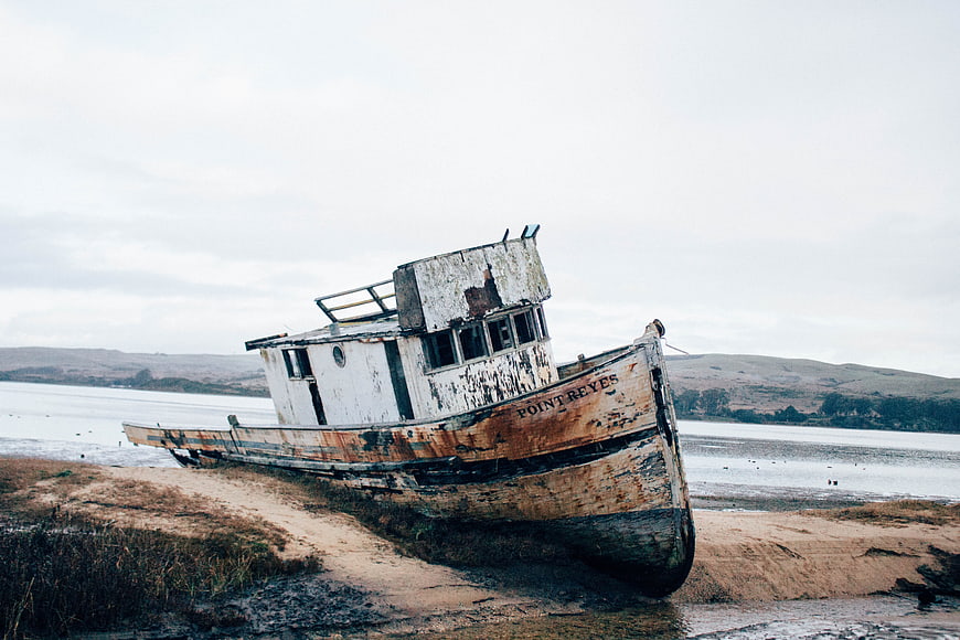 Abandoned Rusty Boat Named Point Reyes Stranded on Sandy Shore