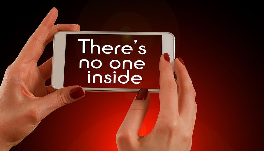 Hands holding smartphone displaying text There's no one inside on red background