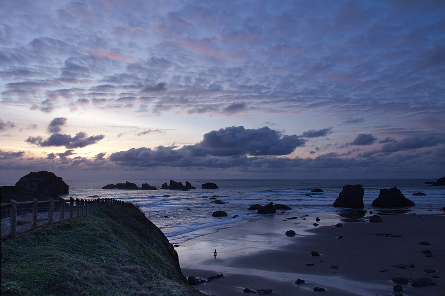 Dramatic Dusk Seascape with Rocky Shore and Cloudy Sky