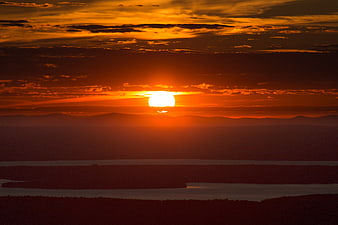 Dramatic Orange Sunset Over Layered Mountain Landscape