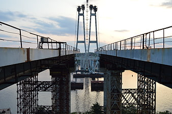 Symmetrical view of a drawbridge opening over a river at sunset