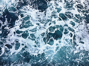 Aerial View of Turbulent Ocean Waves and White Sea Foam