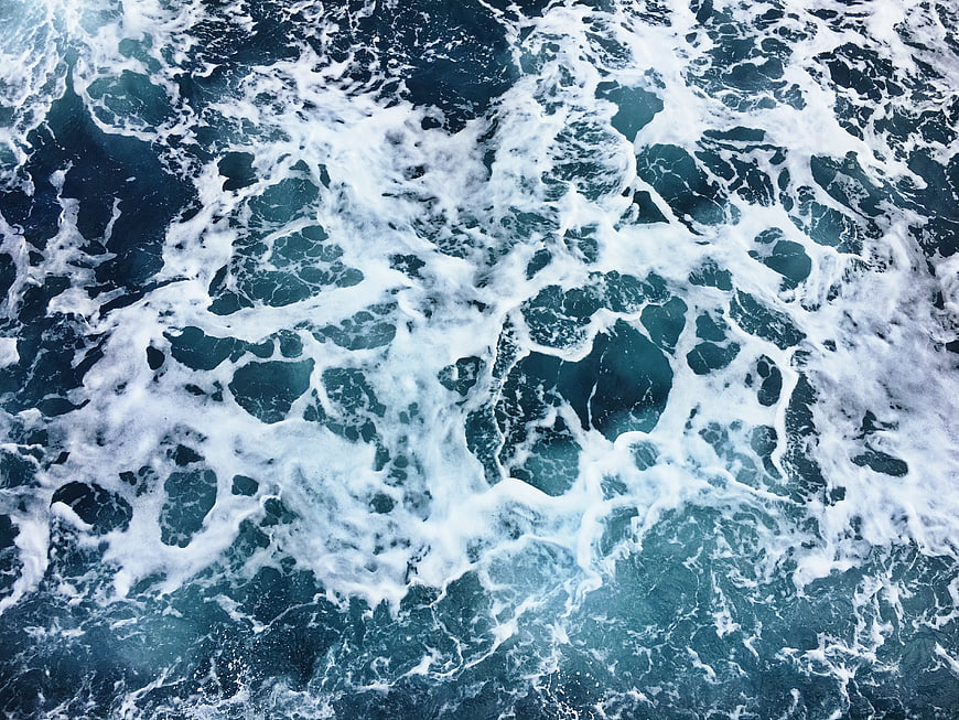 Aerial View of Turbulent Ocean Waves and White Sea Foam