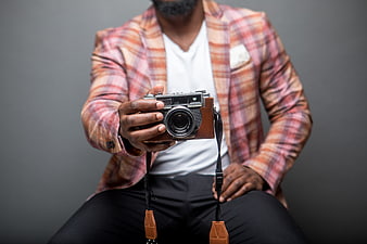 Man Holding Vintage Camera in Plaid Jacket