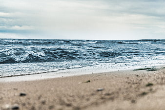 Low angle view of ocean waves crashing on sandy beach