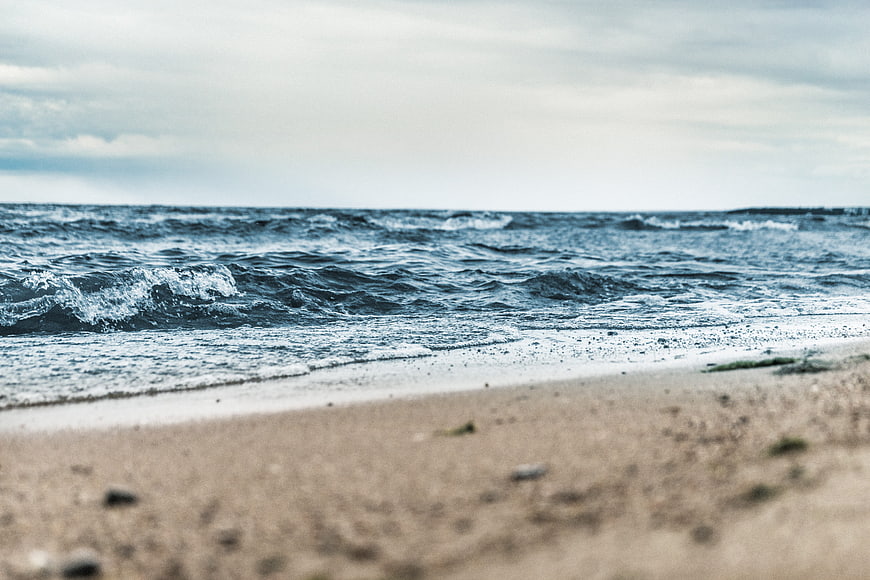 Low angle view of ocean waves crashing on sandy beach