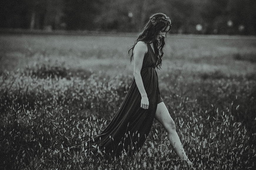 Woman in Dress Walking Through Grassy Field
