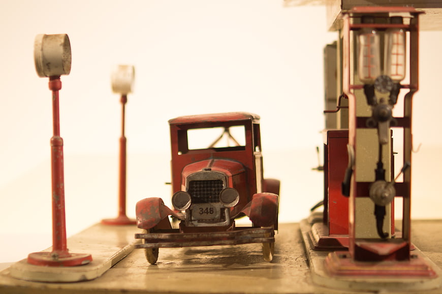 Vintage red toy car at retro gas station diorama
