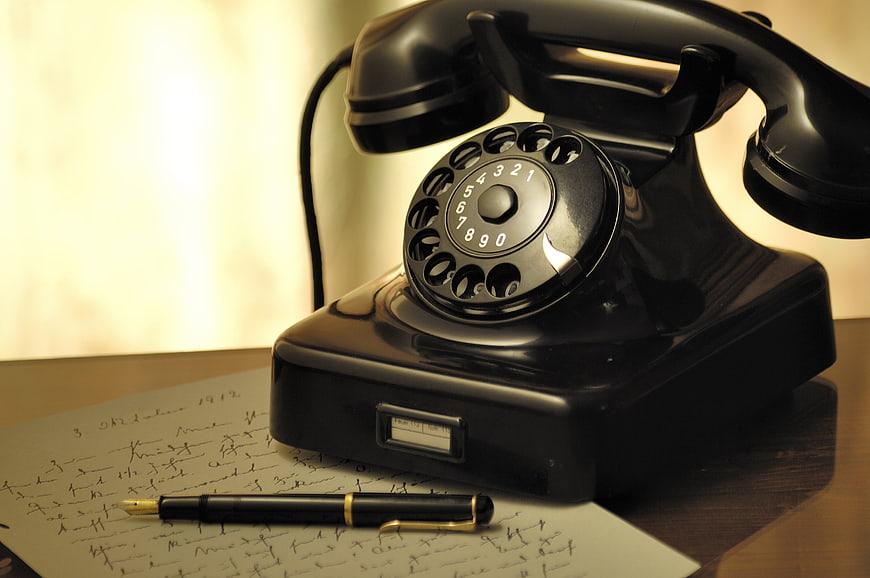 Vintage black rotary telephone with fountain pen and handwritten letter