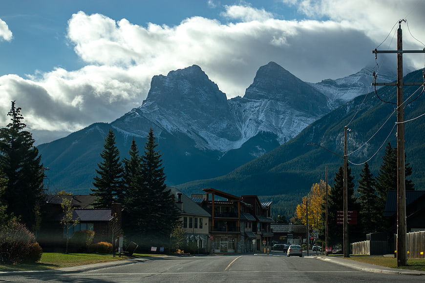 Mountain town street view with snow-capped peaks and pine trees