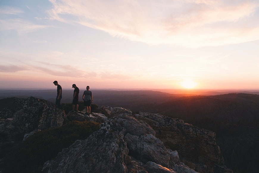 Three Hikers on Rocky Mountain Summit at Sunset