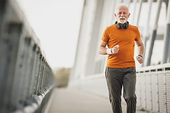 Active Senior Man Jogging on Bridge with Headphones