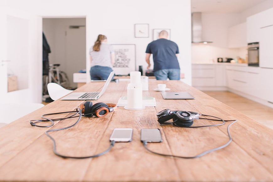 Wooden Table with Headphones, Phones, and Laptops in Modern Home
